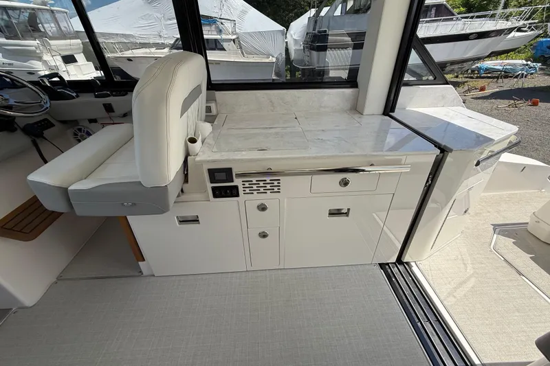  Yacht Photos Pics 2022 Regal 36 XO yacht interior with helm seat and kitchenette area.