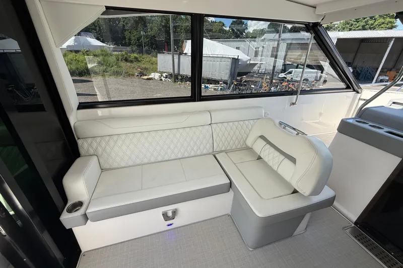  Yacht Photos Pics Interior seating of 2022 Regal 36 XO boat with white upholstery and large windows.