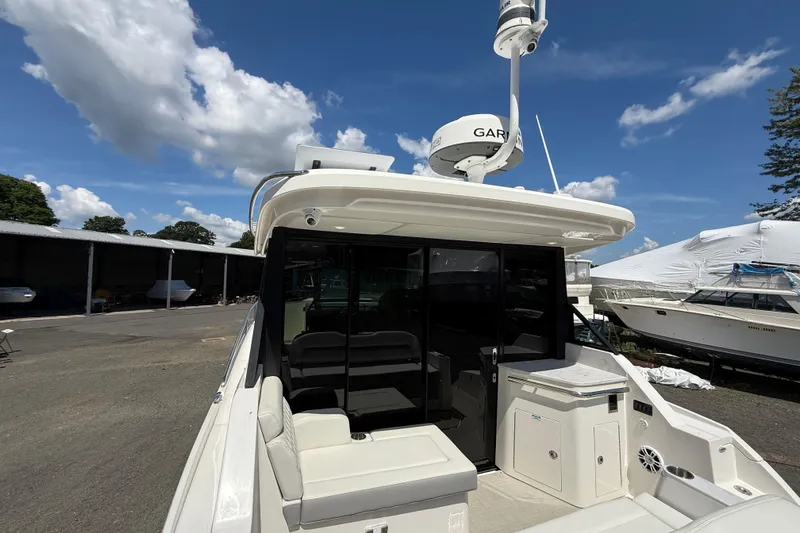  Yacht Photos Pics 2022 Regal 36 XO yacht with seating area, docked under a clear blue sky.