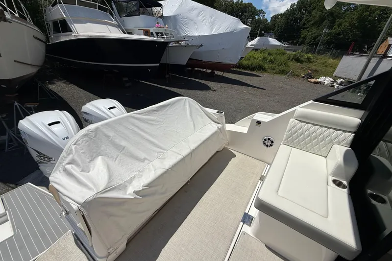  Yacht Photos Pics 2022 Regal 36 XO boat interior with covered seating and twin outboard engines.