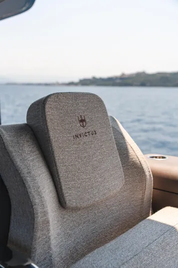  Yacht Photos Pics Luxurious Invictus TT550 boat seat with embroidered logo, 2025 model, overlooking serene water.