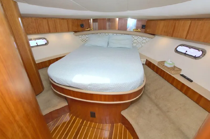 Sunshine Yacht Photos Pics Luxurious cabin interior of 2000 Tiara Yachts 5200 Express with cozy bed and wooden accents.