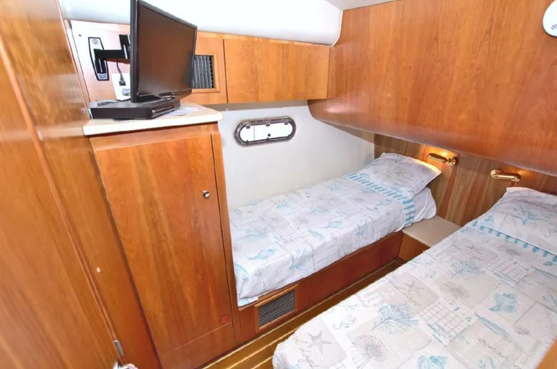 Sunshine Yacht Photos Pics Cabin interior of 2000 Tiara Yachts 5200 Express with twin beds and wooden finish.
