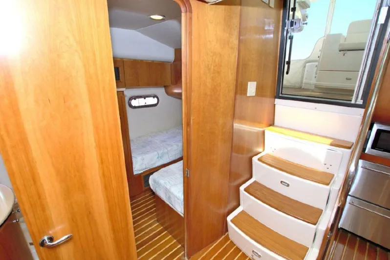 Sunshine Yacht Photos Pics Interior of 2000 Tiara Yachts 5200 Express, featuring wooden cabinetry and cozy sleeping quarters.