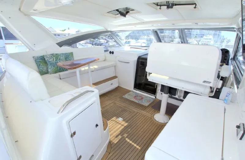 Sunshine Yacht Photos Pics Interior of 2000 Tiara Yachts 5200 Express with white seating and wooden flooring.