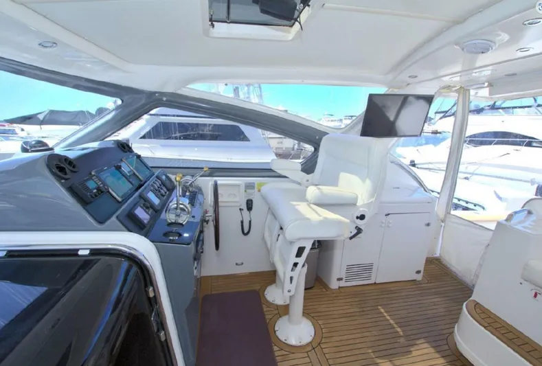 Sunshine Yacht Photos Pics 2000 Tiara Yachts 5200 Express cockpit with helm, seating, and navigation equipment.