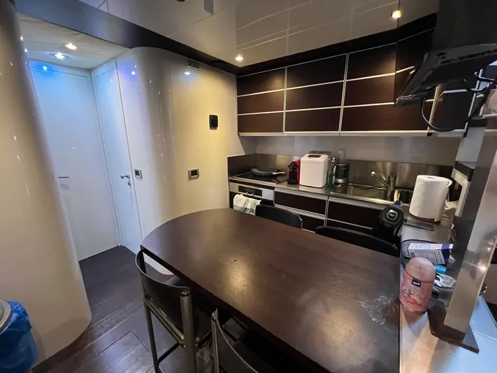  Yacht Photos Pics Modern kitchen interior on a 2006 Azimut 86S yacht, featuring sleek cabinetry and dining area.