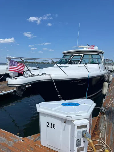  Yacht Photos Pics 2006 Tiara Yachts 3200 Open docked, featuring American flags and clear blue sky.