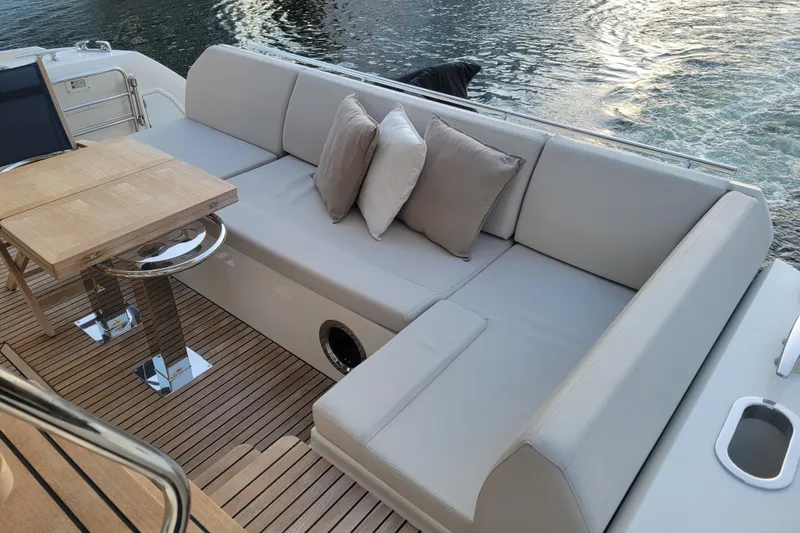 Elles II Yacht Photos Pics Luxurious seating area on 2018 Prestige 520 yacht with cushions and wooden table.