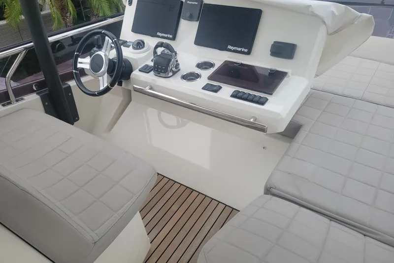Elles II Yacht Photos Pics Helm of 2018 Prestige 520 yacht with modern navigation equipment and cushioned seating.