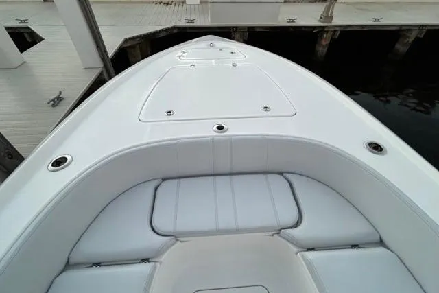 Yacht Photos Pics 2025 Contender 26 Bay boat bow with sleek white seating and storage compartments.