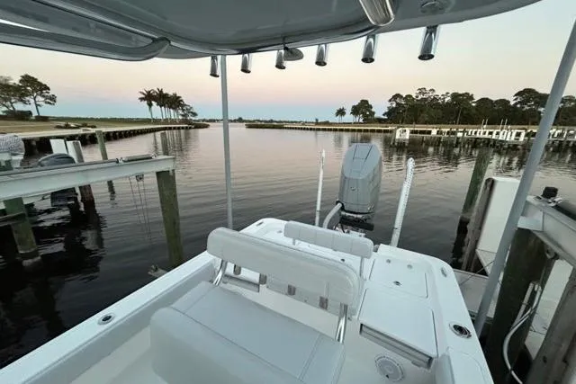  Yacht Photos Pics 2025 Contender 26 Bay boat docked at serene waterfront with palm trees.