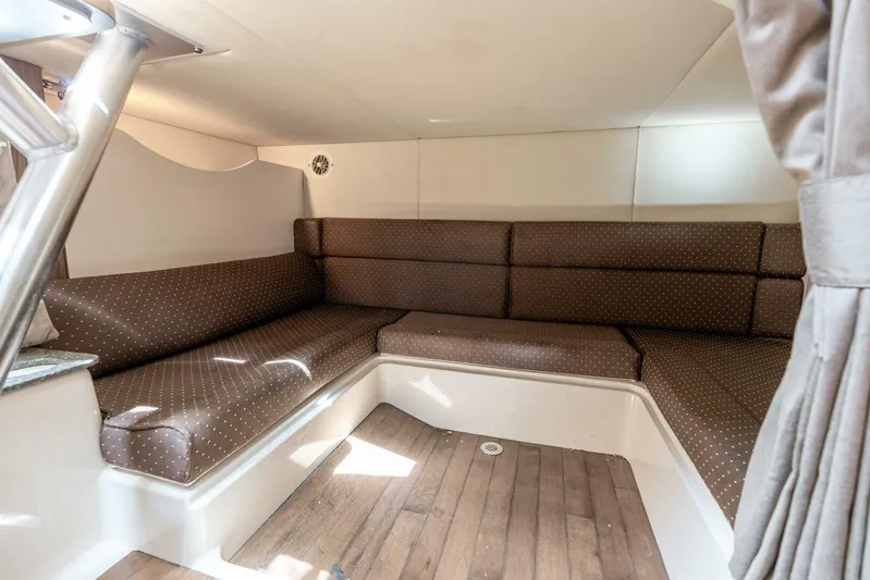 Reel Blessing Yacht Photos Pics 2012 Boston Whaler 345 Conquest cabin interior with brown cushioned seating and wood flooring.