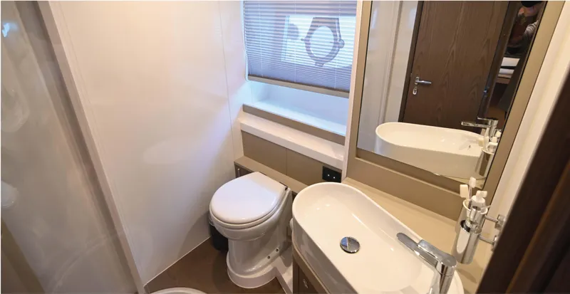  Yacht Photos Pics Luxurious bathroom in 2022 Ferretti Yachts 550, featuring modern sink and toilet.