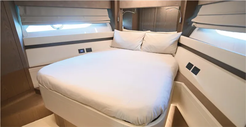  Yacht Photos Pics Luxurious bedroom interior of 2022 Ferretti Yachts 550 with modern design and cozy bedding.