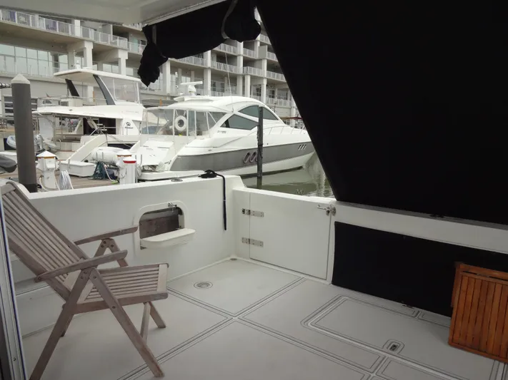 Gypsy Soul Yacht Photos Pics Deck view of 1998 Navigator 53 Classic yacht in marina, featuring wooden chair and docked boats.