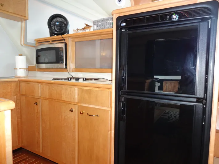 Gypsy Soul Yacht Photos Pics Kitchen area of 1998 Navigator 53 Classic yacht with fridge, microwave, and wooden cabinets.