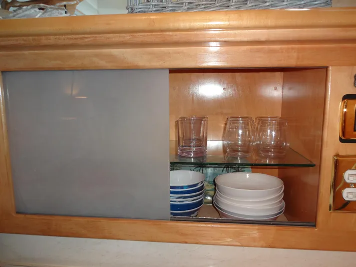 Gypsy Soul Yacht Photos Pics Wooden cabinet with glassware and dishes on a Navigator 53 Classic, 1998 model.