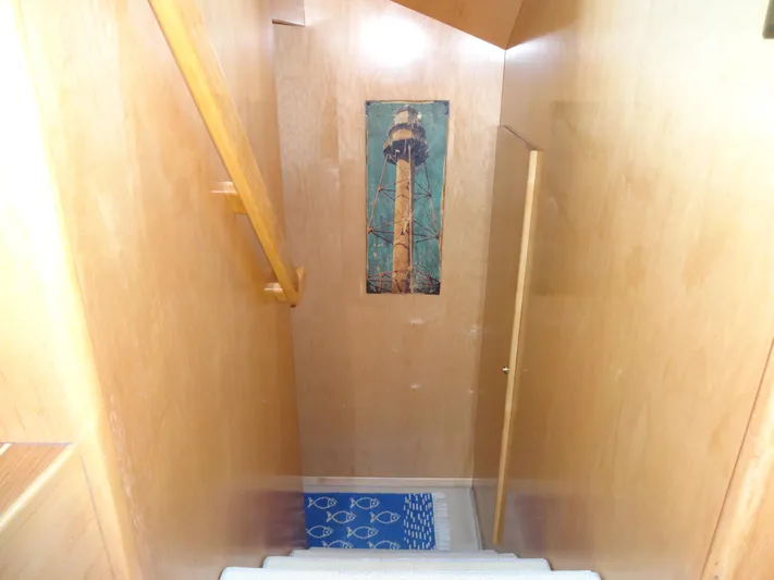 Gypsy Soul Yacht Photos Pics Staircase in 1998 Navigator 53 Classic yacht with wooden walls and lighthouse artwork.