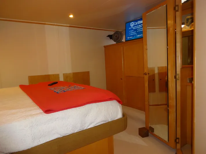 Gypsy Soul Yacht Photos Pics Cozy bedroom interior of 1998 Navigator 53 Classic yacht with wooden cabinets and mirrored door.