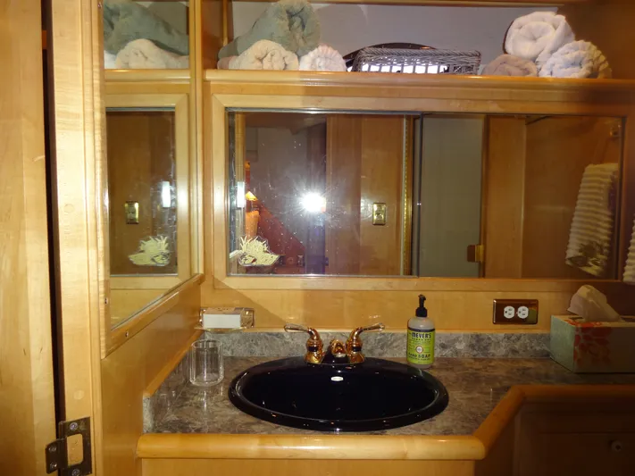 Gypsy Soul Yacht Photos Pics Bathroom vanity with mirror, black sink, and toiletries in a 1998 Navigator 53 Classic.