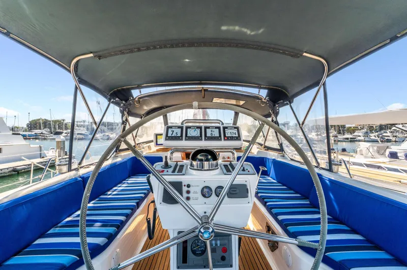 Perfect Symmetry Yacht Photos Pics Hylas 70 yacht cockpit, 2006 model, featuring navigation instruments and blue-striped seating.
