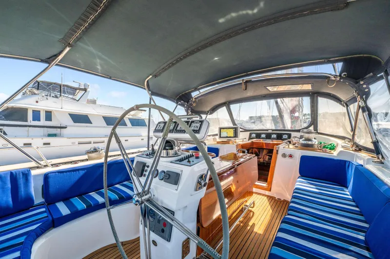 Perfect Symmetry Yacht Photos Pics Interior of 2006 Hylas 70 yacht with blue-striped seating and navigation equipment.