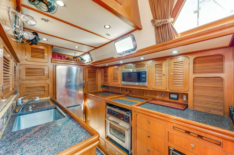 Perfect Symmetry Yacht Photos Pics Luxurious wooden kitchen interior of 2006 Hylas 70 yacht with modern appliances.
