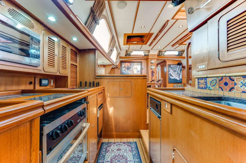 Perfect Symmetry Yacht Photos Pics Luxurious 2006 Hylas 70 yacht interior with wood finishes and modern kitchen amenities.