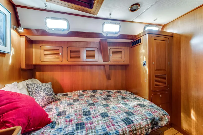 Perfect Symmetry Yacht Photos Pics Cozy cabin interior of 2006 Hylas 70 yacht with wooden finish and comfortable bedding.