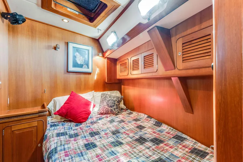 Perfect Symmetry Yacht Photos Pics Cozy cabin interior of 2006 Hylas 70 yacht with wood paneling and bed.