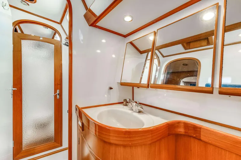 Perfect Symmetry Yacht Photos Pics Luxurious bathroom in 2006 Hylas 70 yacht with wooden accents and modern fixtures.