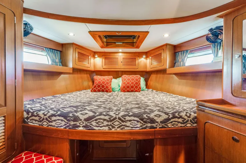 Perfect Symmetry Yacht Photos Pics Luxurious cabin interior of 2006 Hylas 70 yacht with cozy bedding and wooden finish.