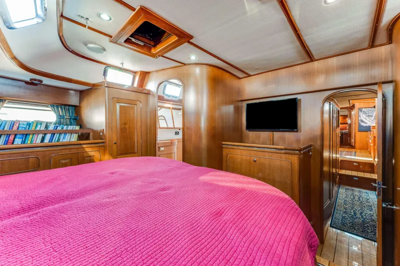 Perfect Symmetry Yacht Photos Pics Luxurious 2006 Hylas 70 yacht cabin with wood paneling and pink bedding.