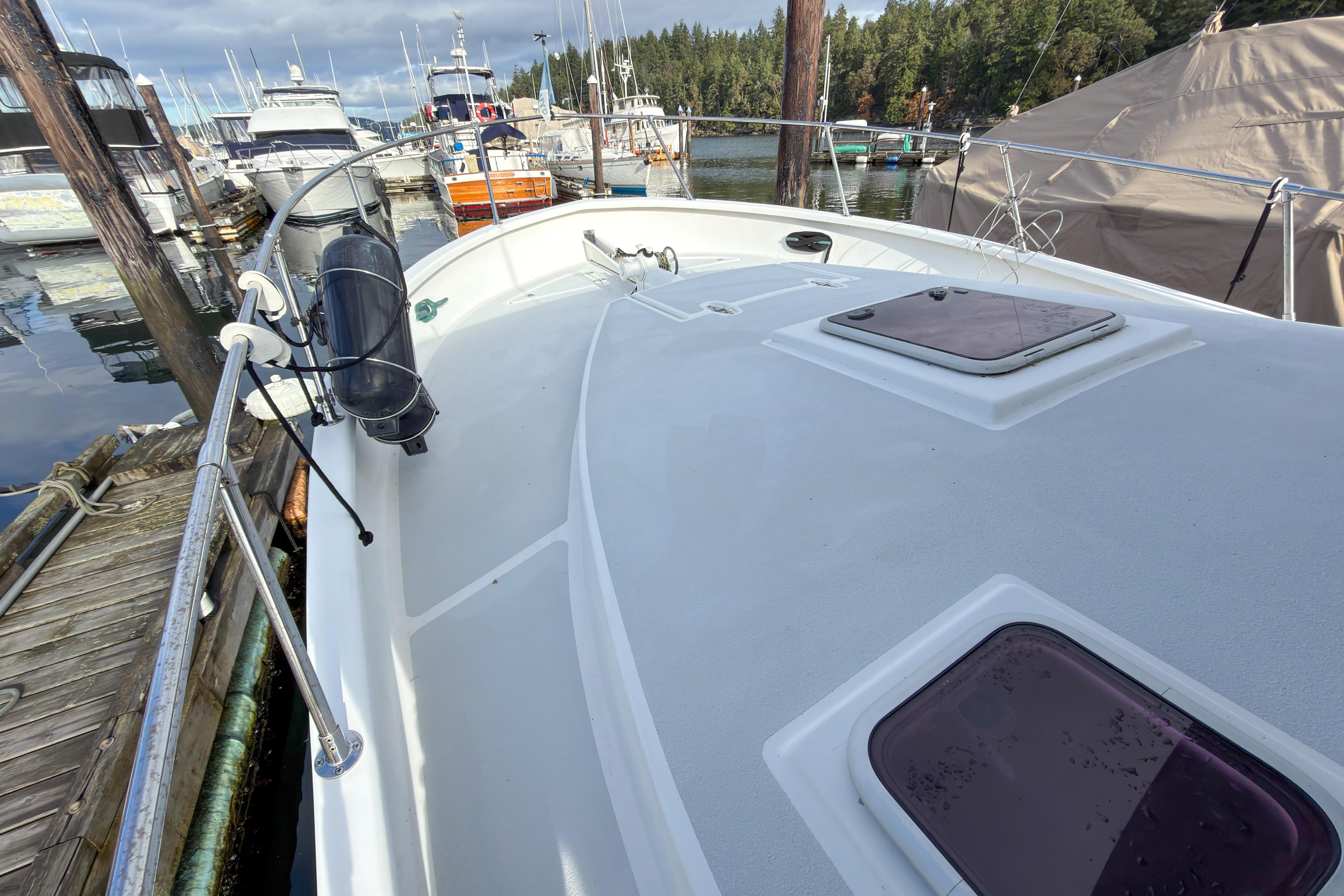 2014 Farrell 34 Pilothouse boat docked at marina, showcasing deck and hatch details.
