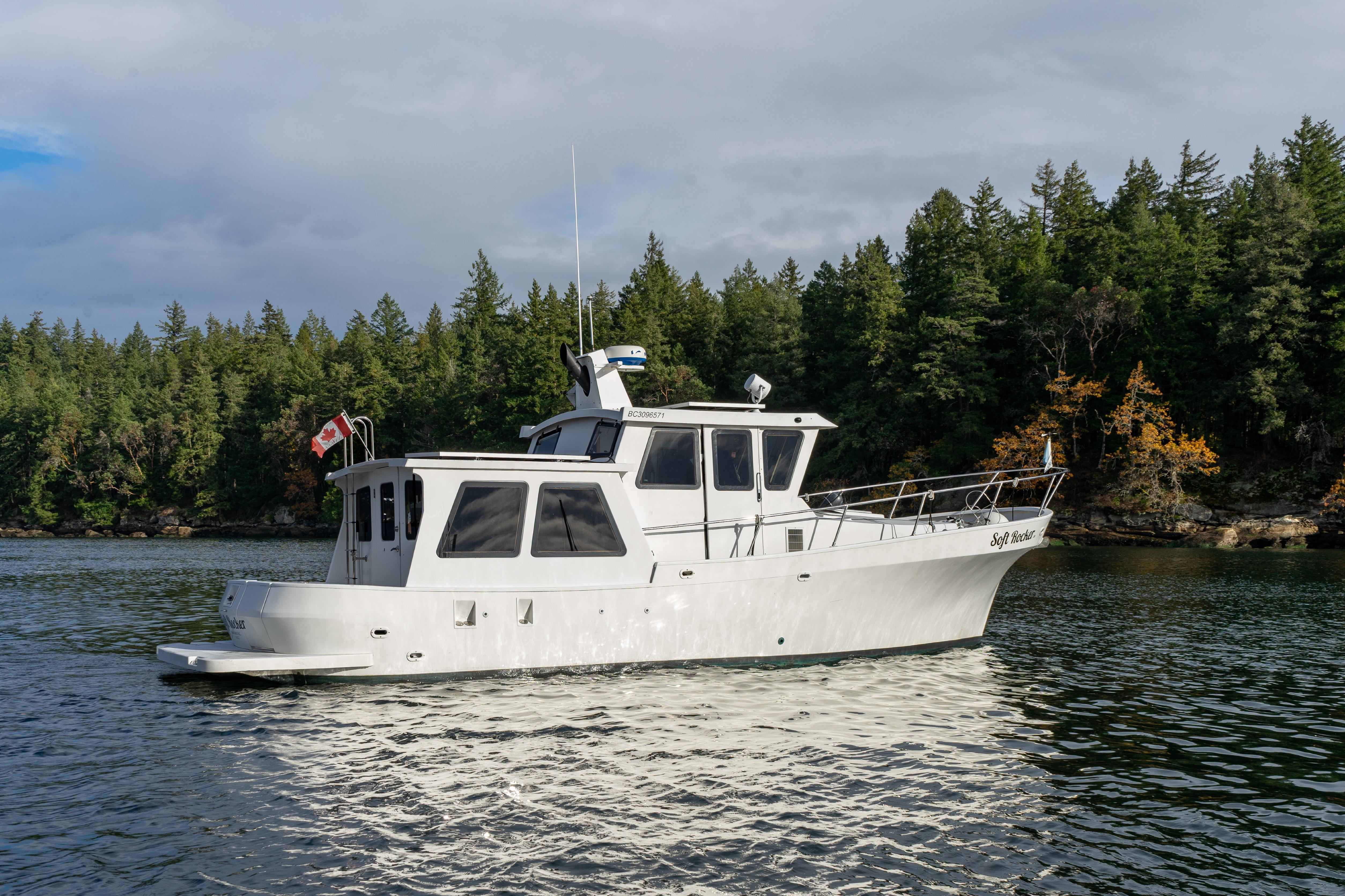 2014 Farrell 34 Pilothouse boat on scenic lake with forested background.