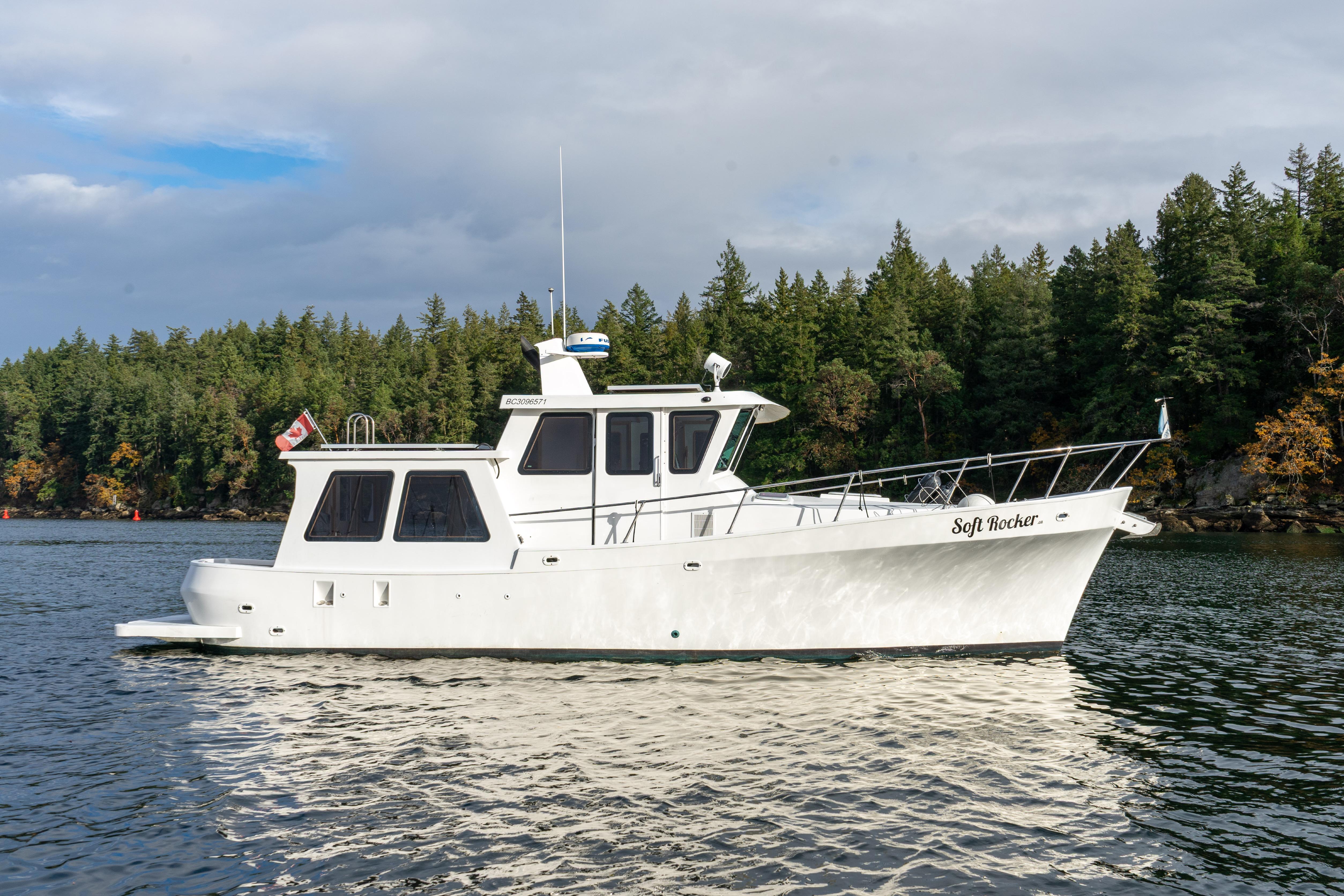 2014 Farrell 34 Pilothouse boat on scenic water with forested background.