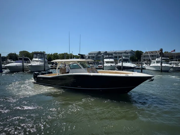  Yacht Photos Pics 2018 Scout 380 LXF boat docked in a marina under clear blue skies.