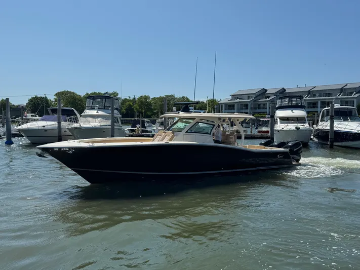  Yacht Photos Pics 2018 Scout 380 LXF boat docked in a marina under clear blue skies.