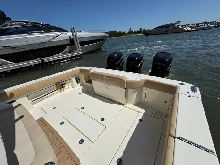  Yacht Photos Pics 2018 Scout 380 LXF boat with triple Mercury engines docked near luxury yachts.