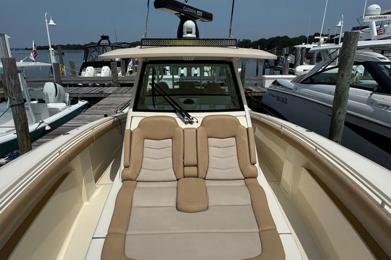  Yacht Photos Pics 2018 Scout 380 LXF boat with cushioned seating at a marina dock.
