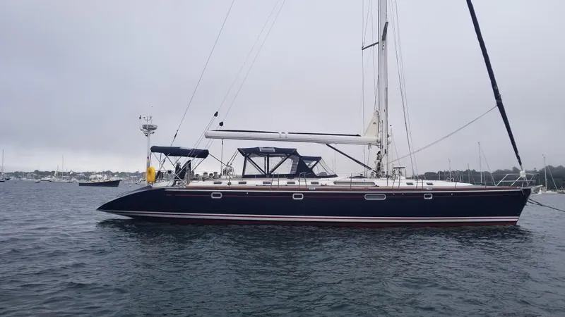  Yacht Photos Pics Sleek 2003 CNB 64 yacht on calm waters, overcast sky in the background.