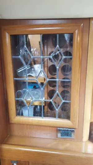  Yacht Photos Pics Wooden cabinet with glass door, showcasing glassware and wine rack on a CNB 64 yacht.