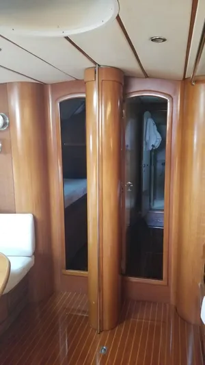  Yacht Photos Pics Luxurious wooden interior of 2003 CNB 64 yacht, featuring elegant doors and cozy cabin space.