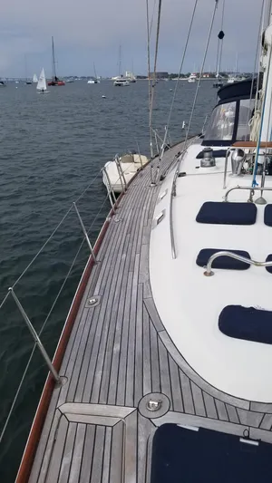  Yacht Photos Pics Sailing yacht CNB 64, 2003 model, on calm waters with visible deck and distant boats.