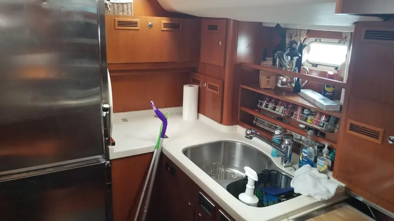  Yacht Photos Pics Galley kitchen in a 2003 CNB 64 yacht with stainless steel appliances.