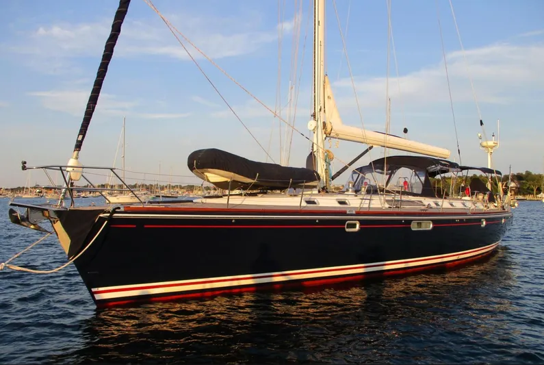  Yacht Photos Pics CNB 64 sailboat from 2003 on calm water at sunset.