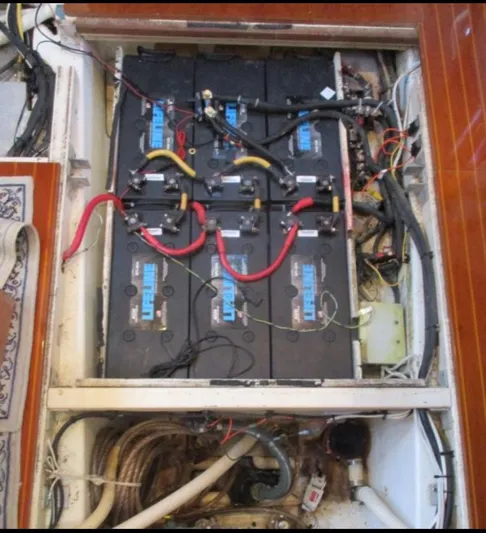  Yacht Photos Pics Battery compartment of a 2003 CNB 64 yacht, featuring multiple connected batteries.