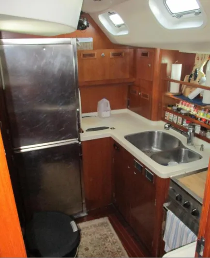  Yacht Photos Pics Galley kitchen in 2003 CNB 64 yacht with wood cabinetry and stainless steel appliances.