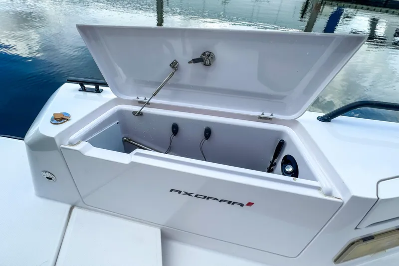  Yacht Photos Pics Open storage compartment on 2022 Axopar 37 Sun-Top boat by the water.